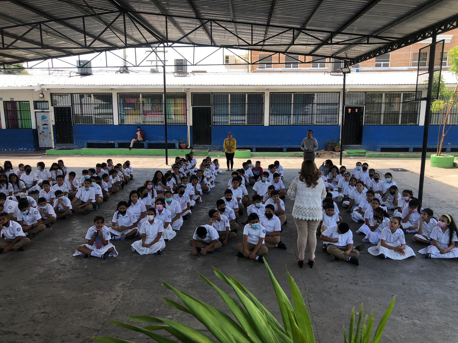 Lesly Nolasco frente a un grupo de estudiantes reunidos al aire libre