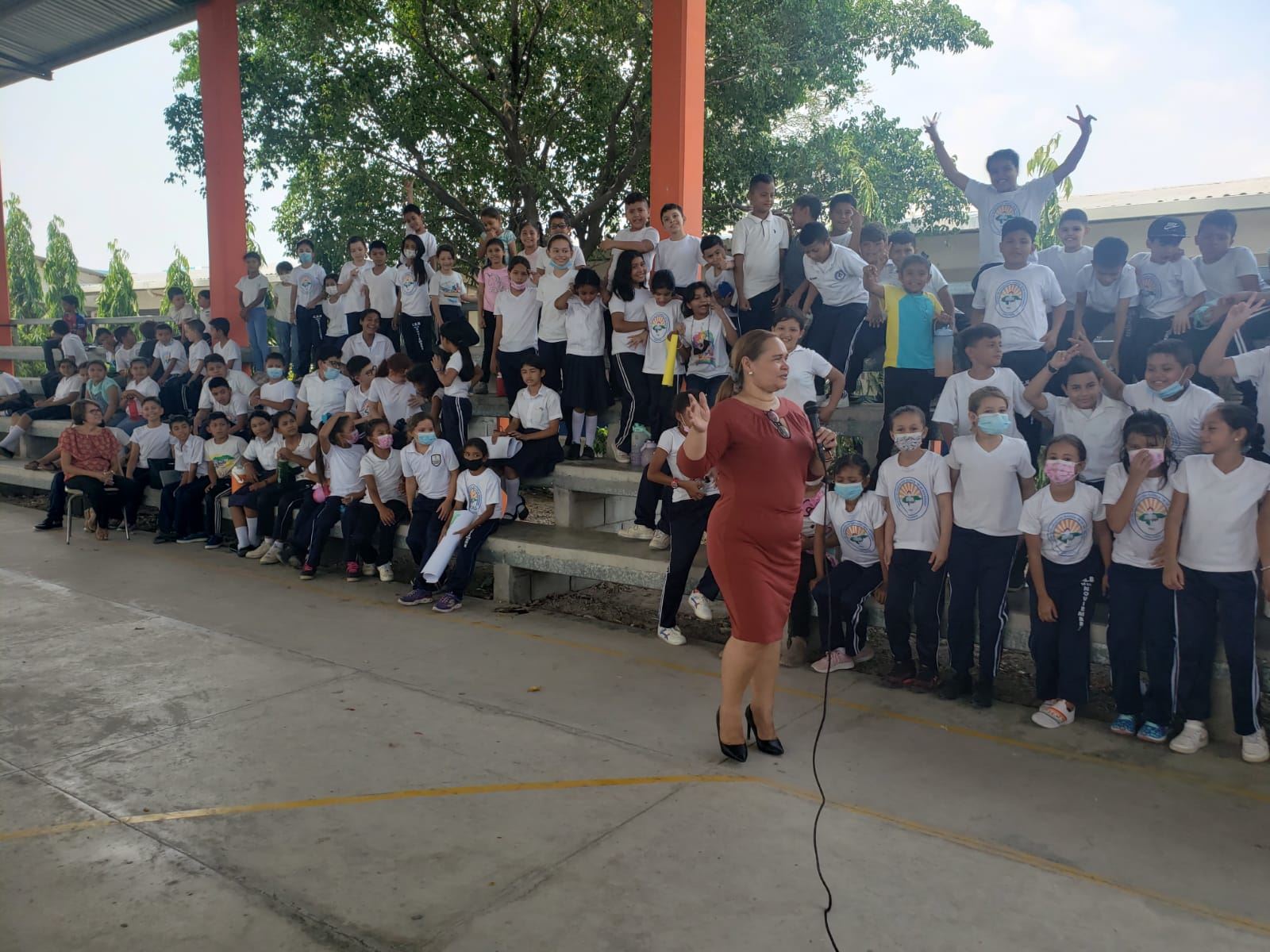 Lesly Nolasco frente a un grupo numeroso de estudiantes al aire libre